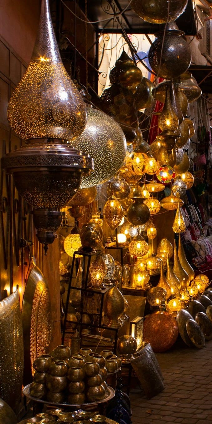 Lampade di ottone traforato accese in una bottega del souk di Marrakech